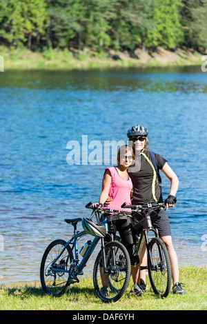 Lächelnde Teenager Biker umarmt am Seeufer Stockfoto