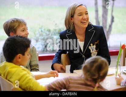 Bundesministerin für Familien Kristina Schroeder (CDU, R) sitzt neben Eileen (vorne), Sergio (L) und Max während eines Besuchs in Kita Pharma- und Chemichal Firma Merck in Darmstadt, Deutschland, 18. Februar 2011. Der Minister will sich mit wie die Firma versucht, bieten ihren Mitarbeitern eine bessere Intigration von Familie und Beruf oder die Hilfe für Frauen in vertraut zu machen Stockfoto