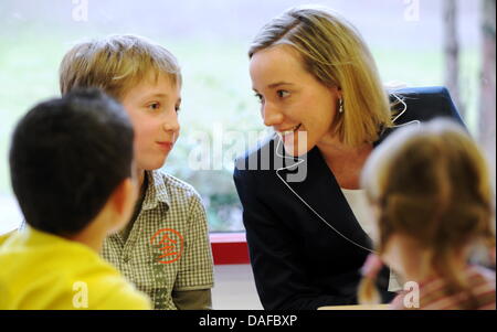 Bundesministerin für Familien Kristina Schroeder (CDU, R) sitzt neben Eileen (vorne), Sergio (L) und Max während eines Besuchs in Kita Pharma- und Chemichal Firma Merck in Darmstadt, Deutschland, 18. Februar 2011. Der Minister will sich mit wie die Firma versucht, bieten ihren Mitarbeitern eine bessere Intigration von Familie und Beruf oder die Hilfe für Frauen in vertraut zu machen Stockfoto