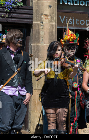 Mitglieder der Black Pig Border Morris Tänzer und Musiker ein farbenfrohes Spektakel von Straßenkünstlern in Bakewell Derbyshire Stockfoto