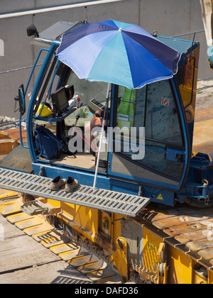 Kran-Treiber auf einer Baustelle mit einer entspannten Haltung gegenüber seiner Arbeit. Breda, Niederlande Stockfoto