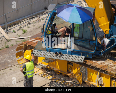 Kranfahrer und sein Kollege mit einer entspannten Haltung gegenüber Arbeit. Breda, Niederlande Stockfoto