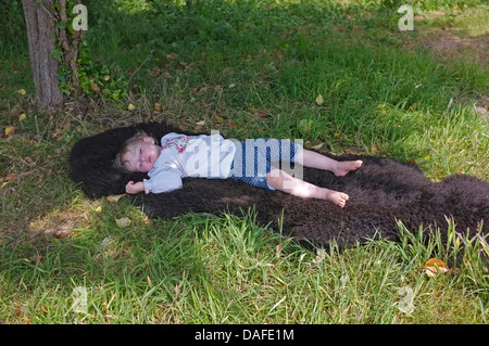 Ein zwei Jahre altes Mädchen schlafend im Schatten Stockfoto