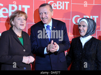 (L, R:) Bundeskanzlerin Angela Merkel, der türkische Ministerpräsident Recep Tayyip Erdogan und seine Frau Emine besuchen die Eröffnung des Information-Technologie-Messe CeBIT in Hannover, Deutschland, 28. Februar 2011. Mehr als 4.200 Unternehmen aus 70 Ländern präsentieren ihre neuesten Produkte auf der weltweit führenden Computer-Expo, die vom 01 bis 05 März stattfindet. Foto: JOCHEN LUEBKE Stockfoto