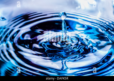 Eine schöne Form, erstellt von der flüssigen Bewegung von Wasser plantschen wie es gegossen wird. Stockfoto