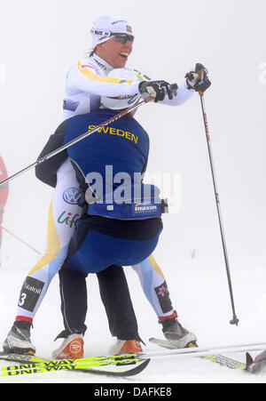 Gewinner Charlotte Kalla von Schweden (R, up) feiert mit Teamkollege Ida Ingemarsdotter (R, unten) nach dem Überqueren der Ziellinie Cross Country Team Sprint Classic Finale der Frauen bei der nordischen Ski-WM in Oslo, Norwegen, 2. März 2011. Foto: Patrick Seeger Stockfoto