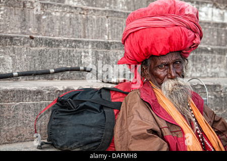 Sadhu, einen großen Turban tragen und sitzen auf den Ghats. Varanasi, Benares, Uttar Pradesh, Indien Stockfoto