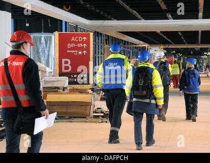 Test Passagiere gehen durch die Haupt-Pier, eines der Tore während eines Testlaufs am künftigen Flughafen Berlin-Brandenburg in Schönefeld, Deutschland, 8. Dezember 2011. Vom Check-in durch die Sicherheitskontrolle besuchen Mitarbeiter von Fluggesellschaften, Polizisten und Globeground Mitarbeiter des Testlaufs am künftigen Flughafen BER. Sobald die Willy-Brandt-Flughafen am 3. Juni 2012, 27 Mühle geöffnet werden Stockfoto