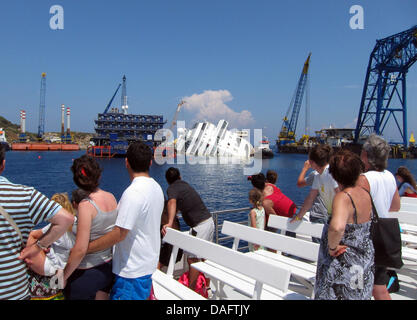 Giglio, Italien. 10. Juli 2013. Touristen sehen die Bergungsarbeiten von der Fähre am Wrack der Kreuzfahrt "Costa Concordia" vor der Küste der Insel Giglio, Italien, 10. Juli 2013 ausgeliefert. Foto: MIRIAM SCHMIDT/Dpa/Alamy Live News Stockfoto