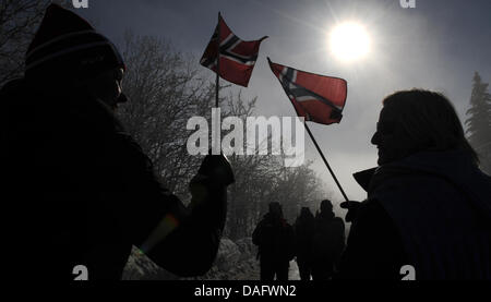 Die Sonne scheint hinter zwei Lüfter, die norwegischen Fahnen auf dem Weg zum Skispringen Veranstaltungsort während der nordischen Ski-WM in Oslo, Norwegen, 3. März 2011 zu halten. Foto: Patrick Seeger Stockfoto