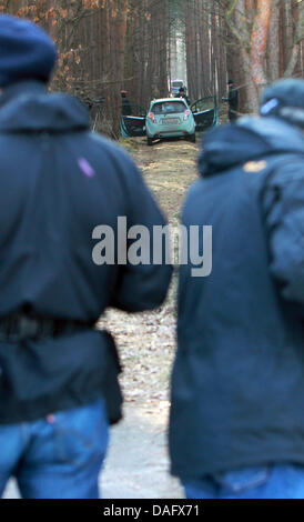 Zwei Journalisten stehen in der Nähe das Auto von einem angeblichen Täter, wo Polizisten nach Spuren in einem Wald zwischen Buelstringen und Wieglitz, Deutschland, 4. März 2011 suchen. Der Besitzer des Autos steht im Verdacht, haben drei Personen auf einem Schießplatz in Genthin geschossen und vermutlich erschoss sich danach. Foto: Jens Wolf Stockfoto