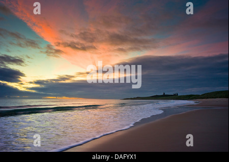 Vor Sonnenaufgang an der Northumberland Küste mit Dunstandburgh Castle in der Ferne Licht. Stockfoto