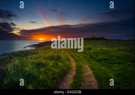 Dämmerlicht an der Northumberland Küste mit Dunstandburgh Schloss in der Ferne. Stockfoto