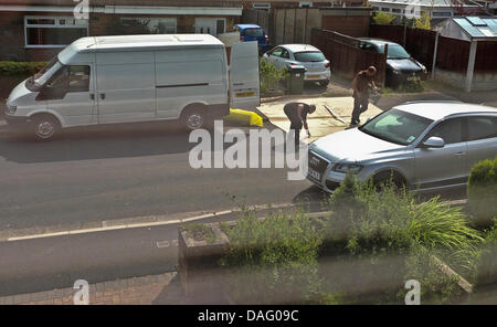 Preston, Lancs, UK. 12. Juli 2013. Teppich Monteure verlegen neue Teppich auf der öffentlichen Straße und Bürgersteig zu zwingen Autos drüber fahren zurechtgeschnitten. Bildnachweis: Sue Burton/Alamy Live-Nachrichten Stockfoto