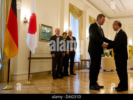 Das Bild zeigt deutsche Präsident Christian Wulff (CDU) (2. R) und Embassador of Japan Takakiro Shinyo (R) Händeschütteln in der japanischen Botschaft in Berlin, Deutschland am 14. März 2011. Wulff besuchte ein Kondolenzschreiben an die japanische Botschaft heute. FOTO: TOBIAS KLEINSCHMIDT Stockfoto