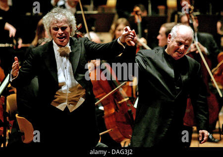Der Chefdirigent der Berliner Philharmoniker, Sir Simon Rattle (L) und der musikalische Leiter des Berliner Schillertheaters, Daniel Barenboim (R), Hände halten, wie sie sich das Publikum Applaus während der Berliner Philharmoniker Benefiz-Konzert in Berlin, Deutschland, 15. März 2011 zu beugen. Das Benefizkonzert wurde organisiert, um zusätzliche Gelder für die "Unter Den Linden" Sta Stockfoto