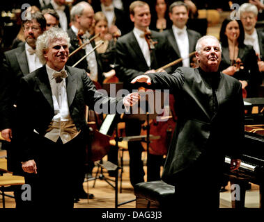 Der Chefdirigent der Berliner Philharmoniker, Sir Simon Rattle (L) und der musikalische Leiter des Berliner Schillertheaters, Daniel Barenboim (R), Hände halten, wie sie sich das Publikum Applaus während der Berliner Philharmoniker Benefiz-Konzert in Berlin, Deutschland, 15. März 2011 zu beugen. Das Benefizkonzert wurde organisiert, um zusätzliche Gelder für die "Unter Den Linden" Sta Stockfoto