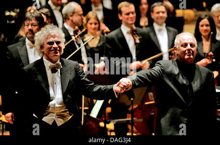 Der Chefdirigent der Berliner Philharmoniker, Sir Simon Rattle (L) und der musikalische Leiter des Berliner Schillertheaters, Daniel Barenboim (R), Hände halten, wie sie sich das Publikum Applaus während der Berliner Philharmoniker Benefiz-Konzert in Berlin, Deutschland, 15. März 2011 zu beugen. Das Benefizkonzert wurde organisiert, um zusätzliche Gelder für die "Unter Den Linden" Sta Stockfoto