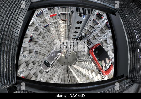 Ein VW Golf Cabrio und ein Passat Variant werden in einen freien Steckplatz in der Autotürme bei Volkswagen Autostadt in Wolfsburg, Deutschland, 9. März 2011 transportiert. Foto: Jochen Luebke Stockfoto