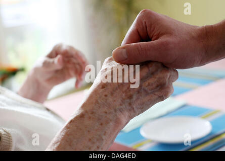 (Dpa-Datei) Ein Datei-Bild vom 13. November 2007 zeigt eine Krankenschwester an einem Patienten Hand im Diakonie-Pflegeheim "Joachim-Neander-Haus" in Düsseldorf, Deutschland. Zwei der wichtigsten deutschen Krankenpflege Verbänden (Deutsche Pflegeverbaende) haben die Notwendigkeit für weniger Bueraucracy in der Pflege vor dem Treffen mit deutschen Gesundheitsminister Rösler am 18. März 2011 geäußert. Foto: Oliver B Stockfoto