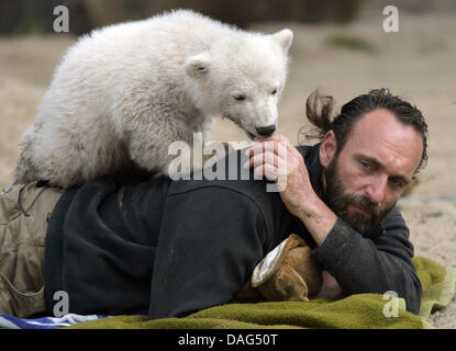 (Datei) - ein Dpa-Datei Bild datiert 8. April 2007 zeigt Geliebter Eisbär Knut, im Alter von vier Monaten, spielt mit seiner Chefin Thomas Doerflein im Zoo in Berlin, Deutschland. Der Zoo-Bär-Experte Heiner Kloes berichtet, dass die vier-jährige Eisbär zusammenbrach und starb an unbekannten Ursachen auf seinem Gelände am 19. März 2011. Knut war eine der Hauptattraktionen des Zoos und beliebt bei Berli Stockfoto