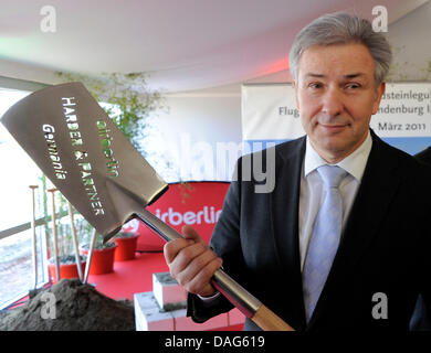 Berlins Bürgermeister Klaus Wowereit hält eine Schaufel nach Festlegung der grundlegenden Steins für eine neue Air Berlin-Hangar in Berlin-Brandenburg International Flughafen (BBI), die noch im Bau in Schönefeld, Deutschland, 21. März 2011 ist. Die neue Halle bietet Platz für sechs Airbus A320 Mittelstrecken-Flugzeuge oder zwei Airbus A330 Langstrecken-Flugzeuge. BBI wird am 03. Juni in Betrieb gehen. Stockfoto