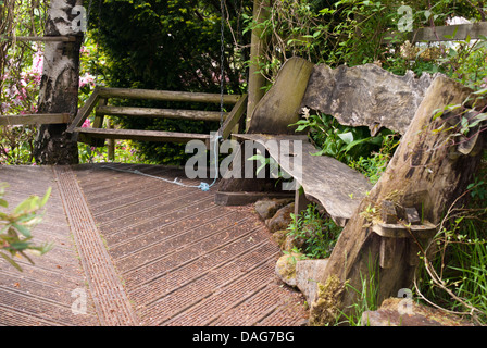 Ein paar leere Bänke unter einem Baldachin von Bäumen Stockfoto