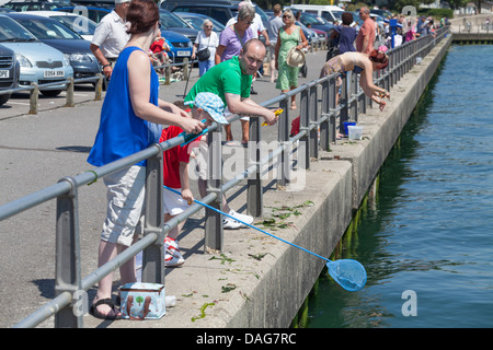 Familiengruppen Verdrehungen auf der Qyay am Mudeford Stockfoto