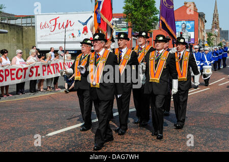 Belfast, Nordirland, 12. Juli 2013 - die jährliche Parade der 12. Juli geht die römisch-katholische St. Patrick-Kirche und ein Protest durch Gemeindemitglieder. Werbe-Banner im Hintergrund liest "Viel Spaß" Credit: Stephen Barnes/Alamy Live News Stockfoto