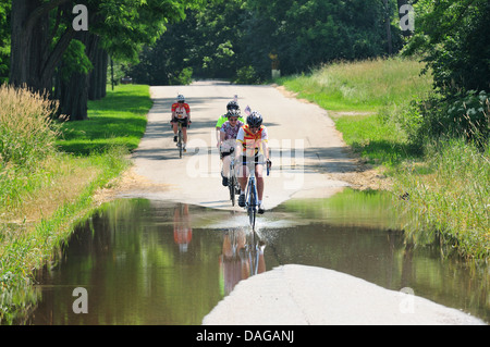 Radfahrer, die teilweise überfluteten Landstraße unterwegs. Stockfoto