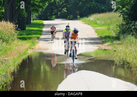 Radfahrer, die teilweise überfluteten Landstraße unterwegs. Stockfoto