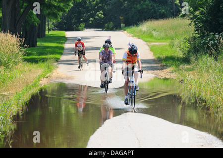 Radfahrer, die teilweise überfluteten Landstraße unterwegs. Stockfoto