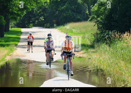 Radfahrer, die teilweise überfluteten Landstraße unterwegs. Stockfoto