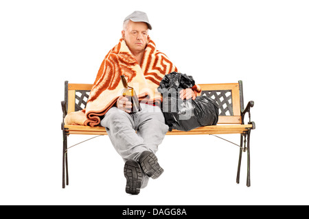 Betrunkene Obdachlose reifer Mann auf einer Bank sitzen und halten Sie eine Flasche Stockfoto