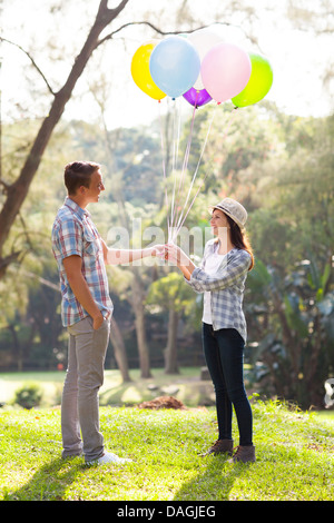 Süße Teenager mit seiner Freundin Helium-Ballons im park Stockfoto