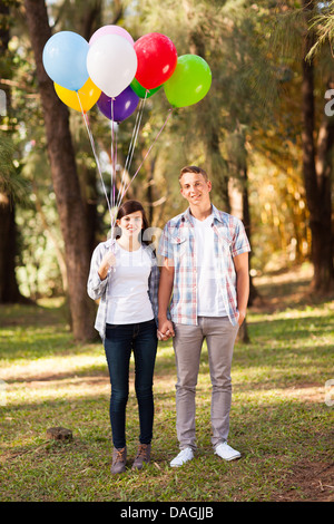 entzückende junge Teen paar mit Helium-Ballons im Wald Stockfoto