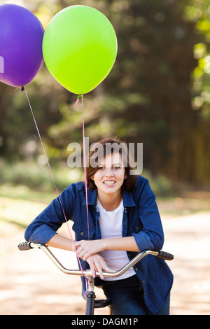 Recht jugendlich Mädchen im Freien mit einem Fahrrad und Helium Ballons Stockfoto