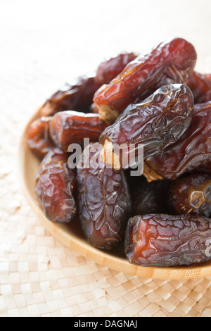 Frucht stammt. Haufen von frisch getrocknete Datum Früchte in einer hölzernen Platte. Stockfoto