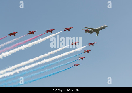 Die britische Royal Air Force rote Pfeile militärische Anzeige Kunstflugstaffel machen eine seltene Bildung Überflug mit einem Bombardier Sentinel Stockfoto