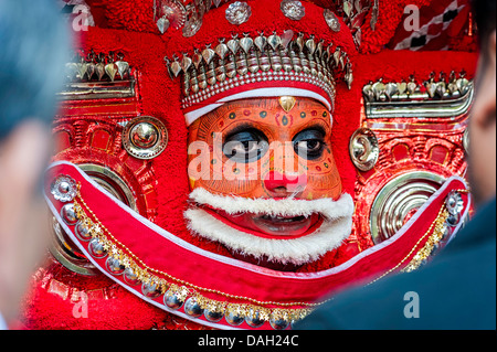 Ein Theyyam Künstler volles Gesicht geschminkt und zeremoniellen Kostüm bei einem Auftritt in Kannur, Kerala, Indien. Stockfoto