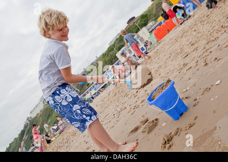 Junge eine Sandburg am Strand von Bournemouth Stockfoto