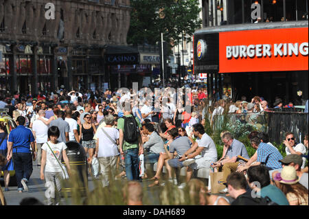 Leicester Square, London, UK. 13. Juli 2013. Leicester Square ist voll von Menschen, die hohen Temperaturen genießen. Bildnachweis: Matthew Chattle/Alamy Live-Nachrichten Stockfoto