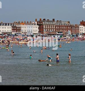Weymouth, UK July 13 2013. In a crowded Weymouth people and pets cool off in the sea during what is expected to be the hottest day of the heatwave so far. Credit:  Tom Corban/Alamy Live News Stockfoto
