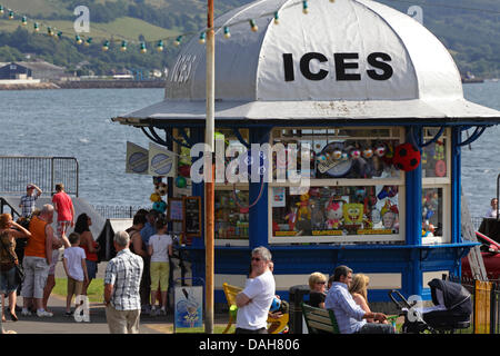 Largs, North Ayrshire, Schottland, Großbritannien, Samstag, 13. Juli 2013. Gäste, die in der Sommersonne am Mackerston Ice Cream Kiosk neben dem Firth of Clyde Schlange stehen Stockfoto