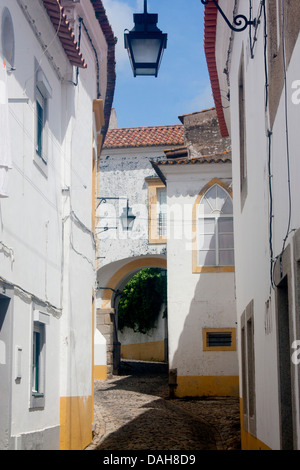 Typisch weiß getünchten Straßenszene gepflasterten mittelalterlichen Straße Rua Freiria de Baixo Evora Alentejo Portugal Stockfoto