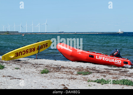 Lifeguard Rescue Board und aufblasbare Boot am Strand von Kastrup, Copenhagen. Middelgrunden Offshore-Windpark im Hintergrund. Stockfoto