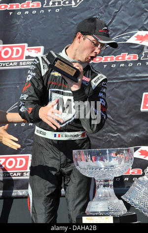 Toronto, Ontario, Kanada. 13. Juli 2013. Toronto, Ontario, Kanada, 13. Juli 2013. Izod Indy Fahrer Sebastien Bourdais reagiert als seinen 2. Platz Trophäe auf den Boden fällt im Sieg-Kreis auf der Honda Indy Toronto an Exhibition Place, Toronto am 13. Juli. Gerry Angus/CSM/Alamy Live-Nachrichten Stockfoto