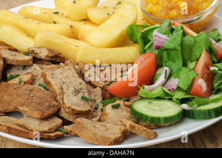 Eine Nahaufnahme auf einer Platte der Scheiben Rindfleisch Kebab Gyros oder Döner Fleisch mit Pommes Frites und Salat Stockfoto