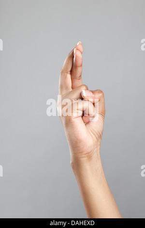 Zarte Frauenhand mit gekreuzten Fingern Stockfoto