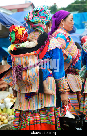 Flower Hmong Frau mit Kind auf dem Rücken am Markt von Bac Ha, Vietnambaby Stockfoto